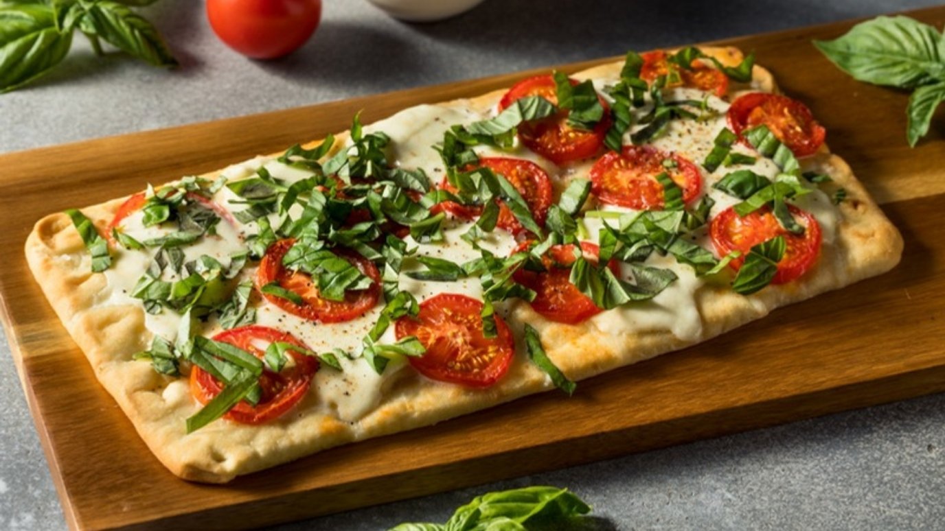 Homemade flatbread topped with tomatoes, basil and cheese